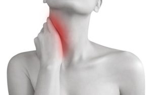 A woman is holding her hand to her neck and there is a red spot on the neck where the pain is.